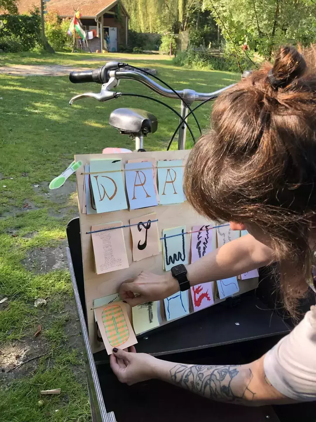 Detail of a person inserting a new letter on the board, by using a clever yet super simple system of rubber bands to keep the paper card in place.