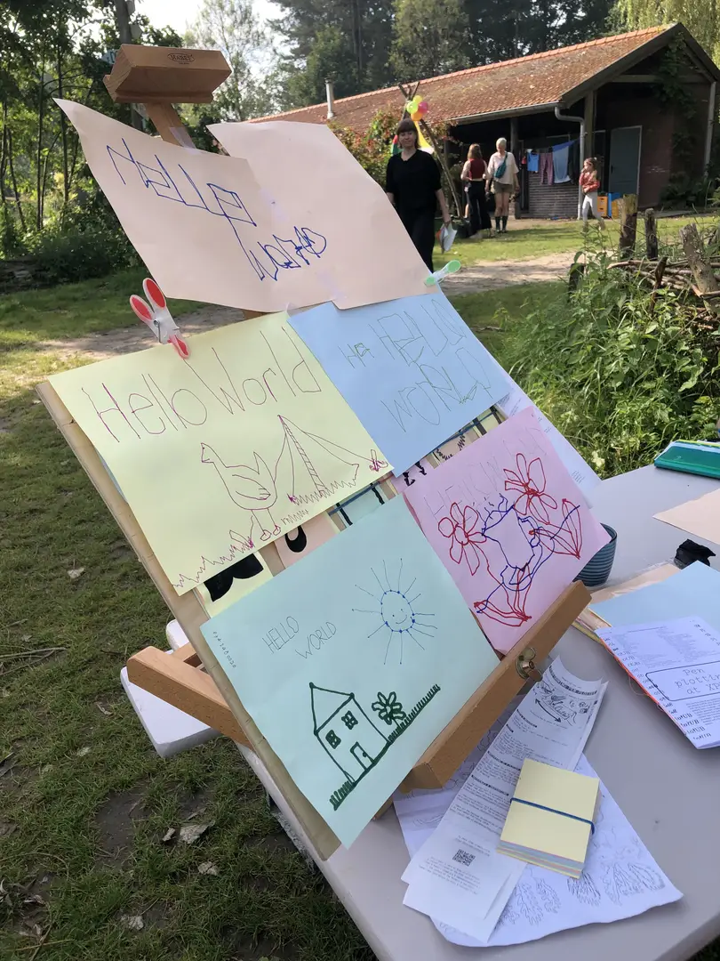 A picture with some drawings on colored sheets of paper. In all of them the words: Hello World is written. The trait is generally shaky and wobbly.