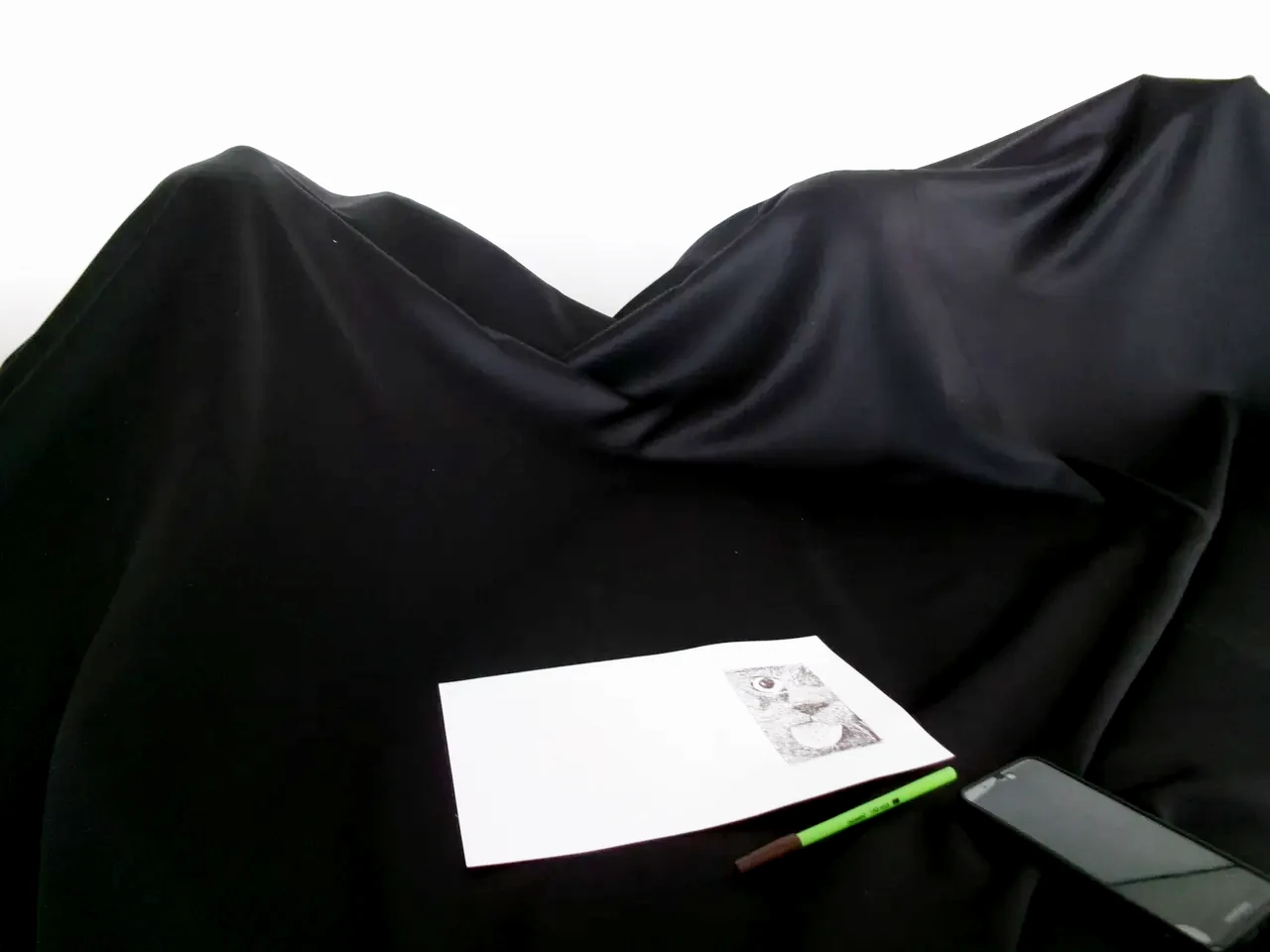 A person tracing the screen of their smartphone on a thin sheet of paper.